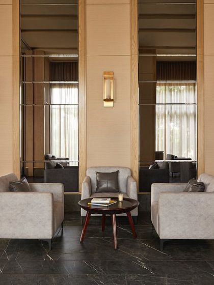 A seating nook in the banquet hall at Rustomjee Elements. The design uses mirror panels to reflect light and create a sense of spaciousness, with comfortable lounge chairs providing a place for quiet conversation.