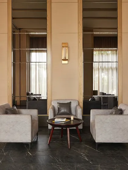 A seating area within the banquet hall, where mirrored wall panels and warm lighting create an intimate and elegant setting.
