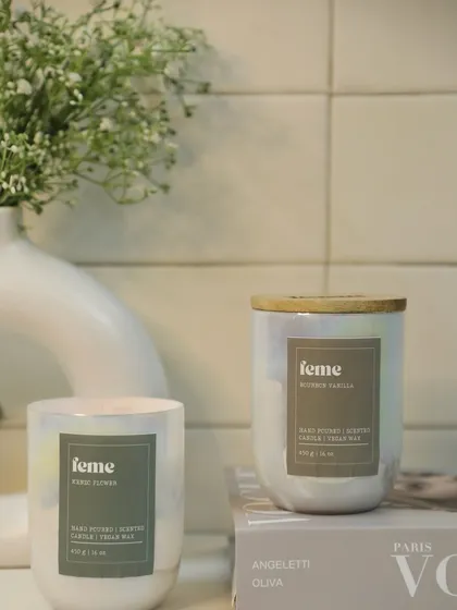 Two of our Holographic Jars, in Kenzo Flower and Bourbon Vanilla scents, styled in a clean, minimalist setting.