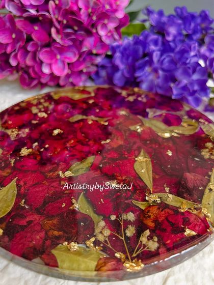 A close-up on the glossy finish of the rose petal coaster. The resin magnifies the rich color and delicate texture of each petal.