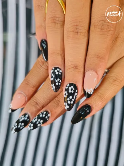 A chic black and white polka dot set with a negative space French tip accent. This student work is modern, clean, and stylish.