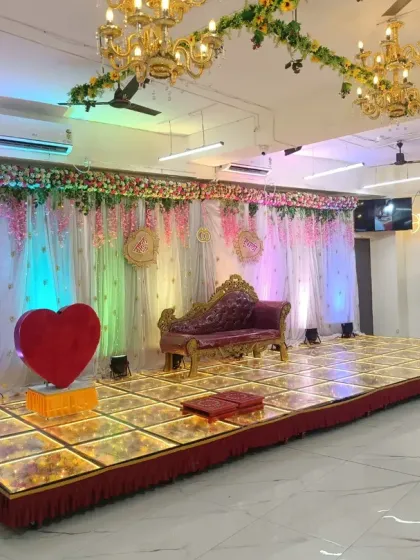 A wide view of the engagement stage, showing the spacious LED floor and elegant chandeliers in our banquet hall.