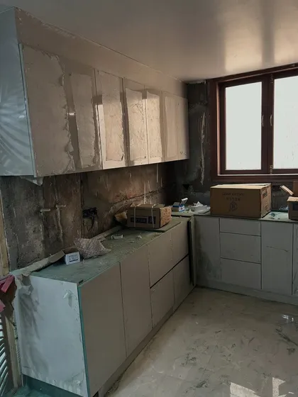 During construction, we make sure to protect all finished elements. Here, the newly installed kitchen cabinets are covered in protective plastic film while other civil work continues.