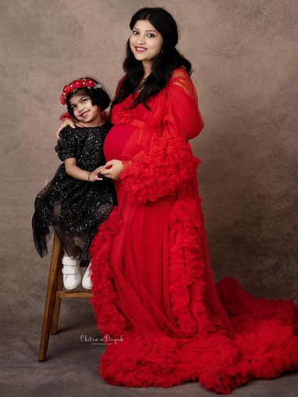 A tender moment between an expecting mother and her daughter, both dressed beautifully for this special family maternity session.