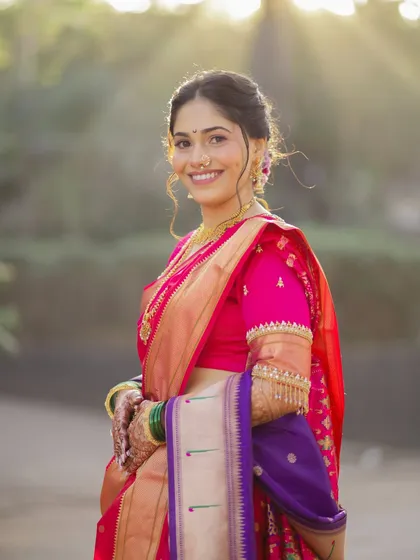 A beautiful outdoor portrait of the bride. Her soft, natural makeup and elegant updo are perfect for this classic Maharashtrian bridal look.