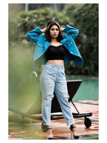 An outdoor fashion shot with a cool, urban vibe. The model's confident stance and stylish outfit create a modern and edgy look.