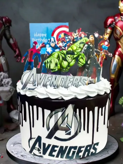 An impressive Avengers-themed drip cake. This design combines a classic chocolate drip with the iconic Avengers logo and a full lineup of heroes for a modern superhero celebration.