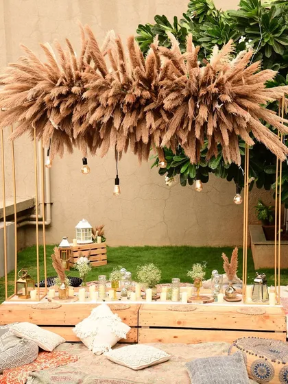 I love designing relaxed, boho-chic sundowners. This rooftop setup features a low sit-down arrangement with plush cushions, a custom pampas grass installation, and warm lighting to create the perfect, dreamy vibe as the sun sets.