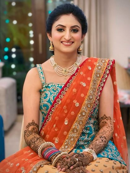 The complete look for Shruti's Mehendi. The bright colors of her outfit are balanced with classic, elegant makeup.