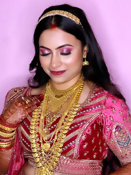 The complete reception look for Pooja. The heavy gold jewelry and vibrant makeup create a look of pure South Indian glamour.