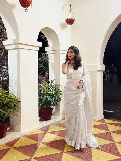 A final look at the white sari, styled with a simple bindi and necklace. Sometimes, the most impactful looks are the most understated.