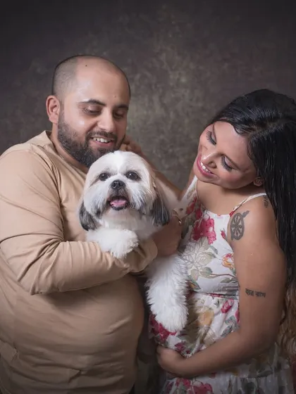 A candid moment of affection during the studio maternity shoot. The expecting parents share a loving look at their happy dog, showcasing the genuine emotion I aim to capture.