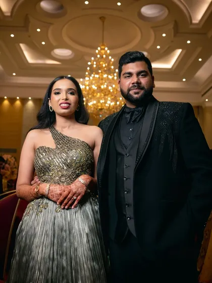 A stylish portrait of the couple against the grand backdrop of the hotel's chandelier and architecture.