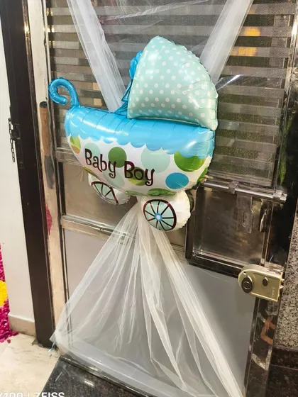 A simple and sweet decoration for the front door, using a "Baby Boy" carriage foil balloon and white netting.