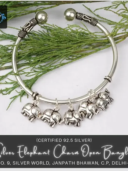 This twisting open bangle features adorable elephant charms. It's a lucky and playful accessory, perfect for adding a touch of ethnic fun.