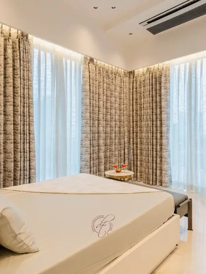 A wide shot of the bedroom, showing the full expanse of the curtains and the simple, elegant layout. The space feels open, peaceful, and uncluttered.