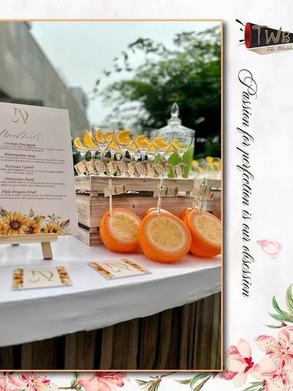 A close-up of our brunch mocktail bar, with custom-branded orange-shaped glasses and a menu highlighting our creative drinks.