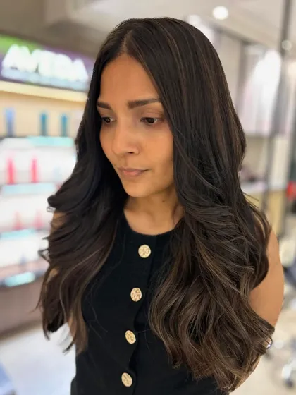 A portrait of the client with her warm mocha highlights and long layers. The color and cut work together to create a soft, beautiful, and healthy look.