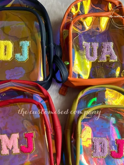Make a splash in style! These iridescent, transparent mini backpacks are perfect as custom swim bags for kids. Each one is personalized with sparkling initial patches.