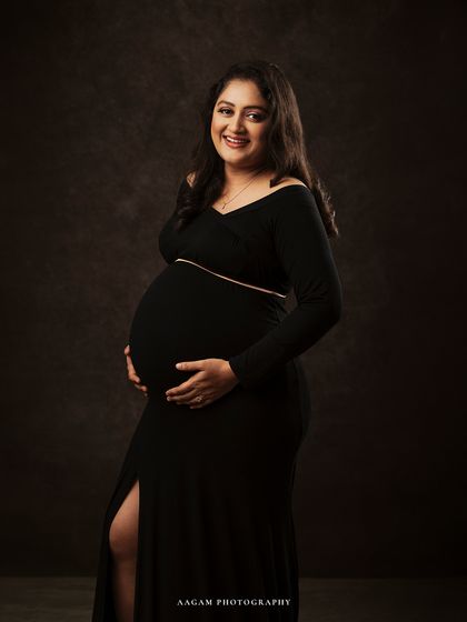 Her joyful smile lights up the frame. This portrait captures the happiness and excitement of waiting to meet her little one.