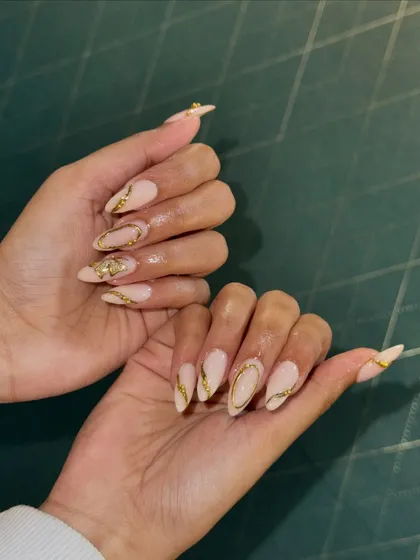 Here’s another angle of the gold-accented nail extensions. Notice how the light catches the metallic details, creating a unique and luxurious effect. I build my extensions to be durable, so you can enjoy your beautiful nails without worry.
