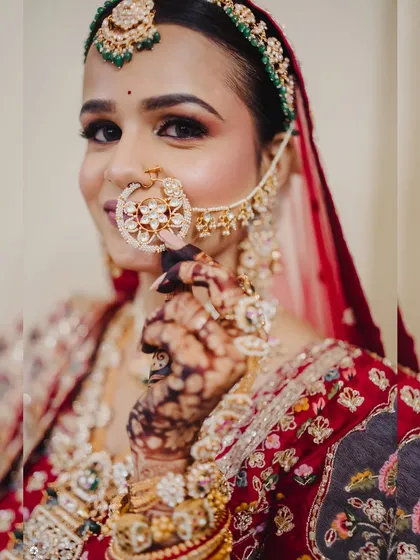 A detailed shot of the bridal nath and makeup. The winged eyeliner and warm tones on the eyes create a captivating and timeless bridal look.