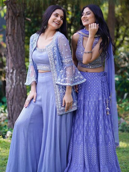 This candid moment between the models adds a layer of authenticity to the fashion shoot. It highlights the comfortable yet stylish nature of the ethnic wear in a relaxed, outdoor environment.
