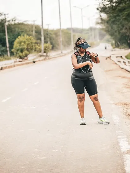A runner checking her watch, staying on top of her pace and time. We teach our athletes to run smart.
