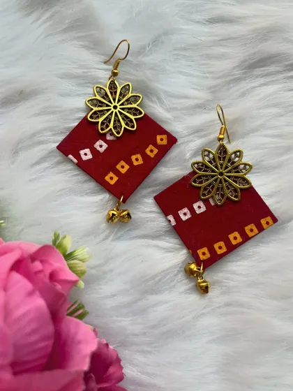 A personal touch for your outfit. This pair of red bandhani print fabric earrings is adorned with a gold-tone floral charm and tiny ghungroos. They are completely handmade and perfect for casual wear.