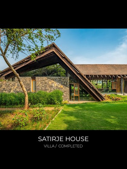 The Satirje House, a recently completed villa, showcases a dramatic roofline that slopes down to meet the earth. The design uses a combination of natural stone and a wooden roof structure to create a home that is both grounded and expansive.
