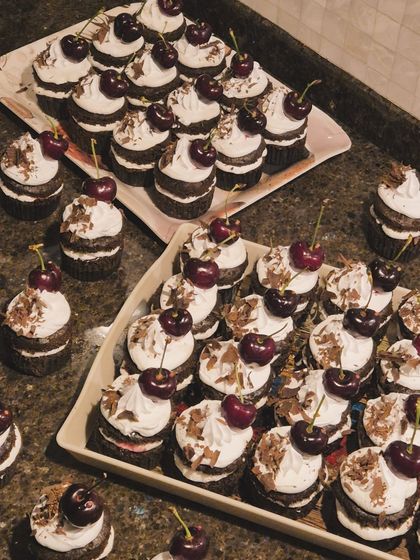 An overhead view of the Black Forest cupcakes. You can see the fluffy cream swirls, chocolate shavings, and juicy cherries that make them so irresistible.