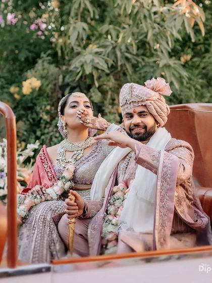 A fun moment with the bride and groom during their baraat. The bride's mehendi is beautifully visible as she playfully interacts with her partner.