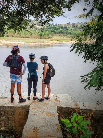 Three riders pause at a viewpoint overlooking a lake. Our tours are a great way to connect with fellow nature lovers and enjoy the outdoors together.