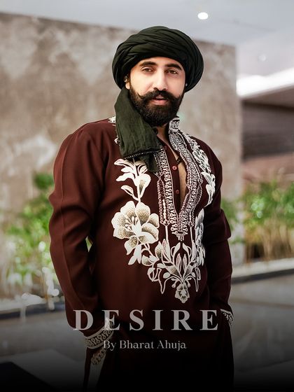The portrait of a modern maharaja. This custom maroon kurta features bold, oversized floral embroidery, a design choice that is both artistic and masculine.