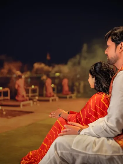 Witnessing the divine spectacle of the Ganga Aarti together. This shot captures the couple absorbed in the ceremony, a shared spiritual experience that strengthens their bond.