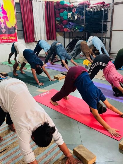 Students practice Adho Mukha Svanasana (Downward-Facing Dog) in our studio. This foundational pose is a part of almost every class, helping to build strength and lengthen the entire body.