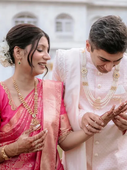 A playful moment where the groom admires his bride's henna. These are the memories that last a lifetime.