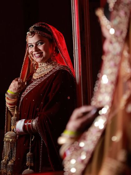 A beautiful mirror shot of our bride Kirti. The warm lighting enhances her glowing makeup and the rich color of her velvet lehenga.
