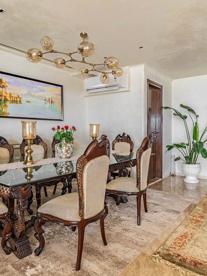 A wider view of the 'Eternity' dining room, showing the relationship between the classic dining set, the modern art, and the surrounding space.
