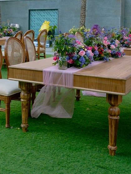 A closer look at the guest tables, showing the beautiful wooden furniture and the simple yet elegant floral centerpieces.