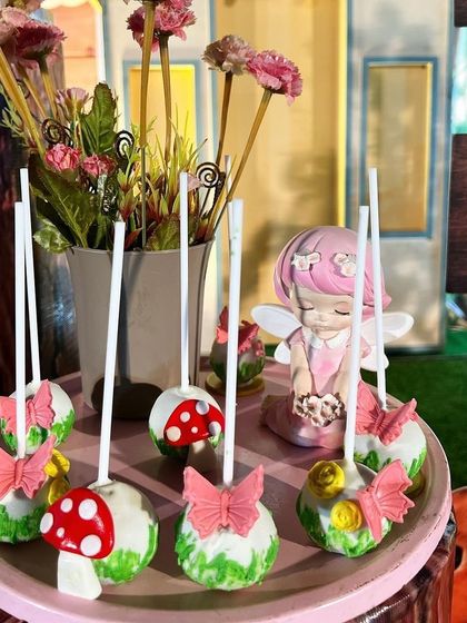 Delicious and cute cake pops designed to look like mushrooms and butterflies, adding to the magical feel of the dessert table.