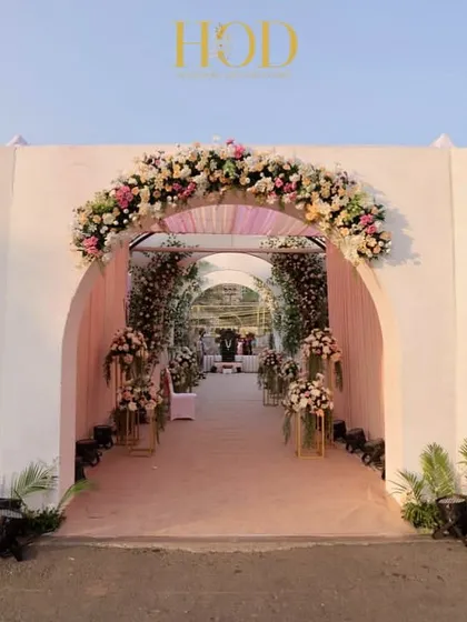 A grand outdoor entrance with painted cherry blossom motifs and floral arches, creating a unique and artistic welcome for guests.