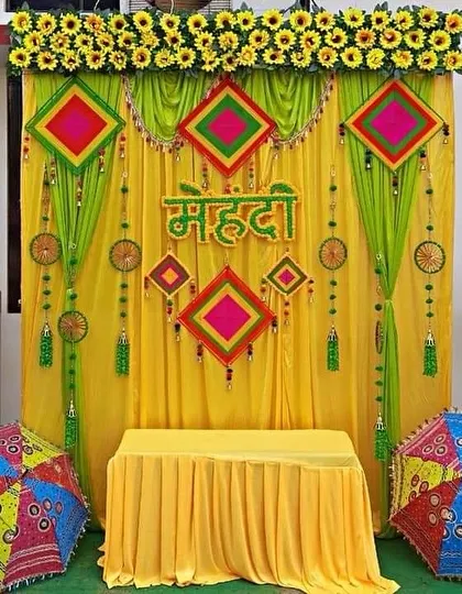 This is one of my classic and most requested Mehndi decor setups. The combination of bright yellow and green drapes, traditional hangings, and colorful Rajasthani umbrellas creates a festive and vibrant space for your ceremony.