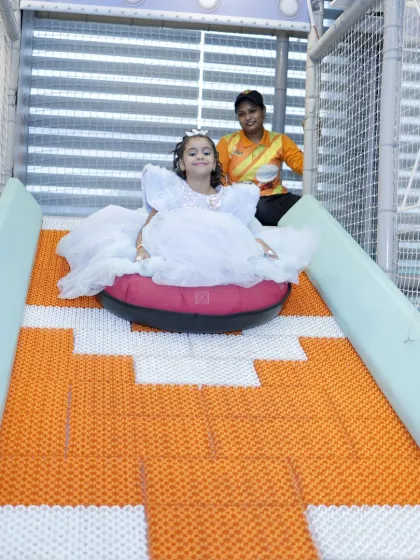 Dressed like a princess, this girl enjoys a magical ride down our popular doughnut slide, supervised by our attentive staff.
