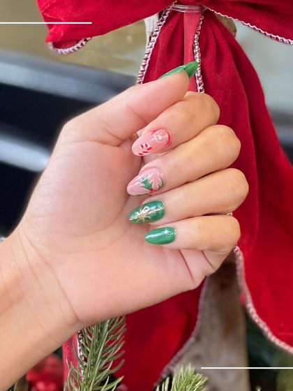 Holiday-ready nails featuring a mix of green and pink, with charming Christmas-themed art like wreaths and candy canes.
