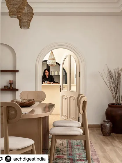 A look from the dining area into the bar, as seen in Architectural Digest. This image captures the seamless flow between spaces, unified by arched doorways and a consistent, warm aesthetic that encourages entertaining.