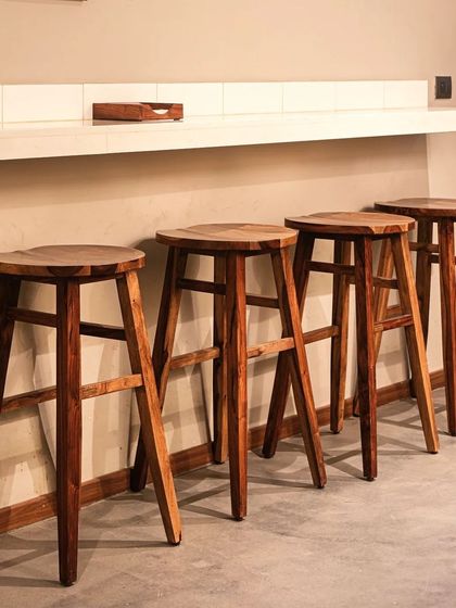 Custom-designed wooden bar stools at the Subko Coffee counter provide a warm, natural touch to the space.