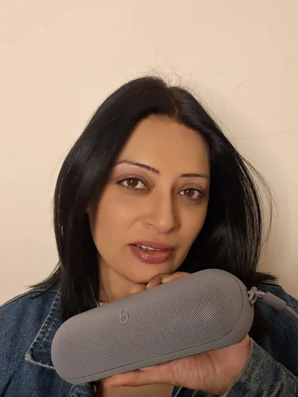 A portrait with the Beats Pill speaker, highlighting its sleek design. This type of content is for brands that want to emphasize the aesthetic appeal of their technology.