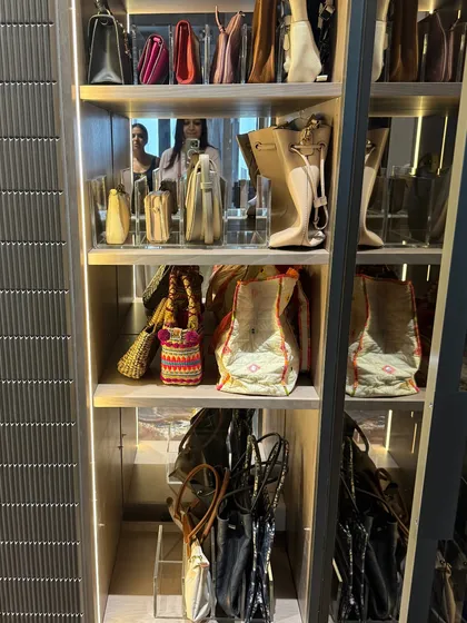 This image captures how we use vertical space to store a large handbag collection, with larger totes on top and smaller bags arranged below.