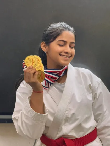 A moment of pure happiness. This red-belt student closes her eyes, cherishing the weight of the medals she has earned through her perseverance.